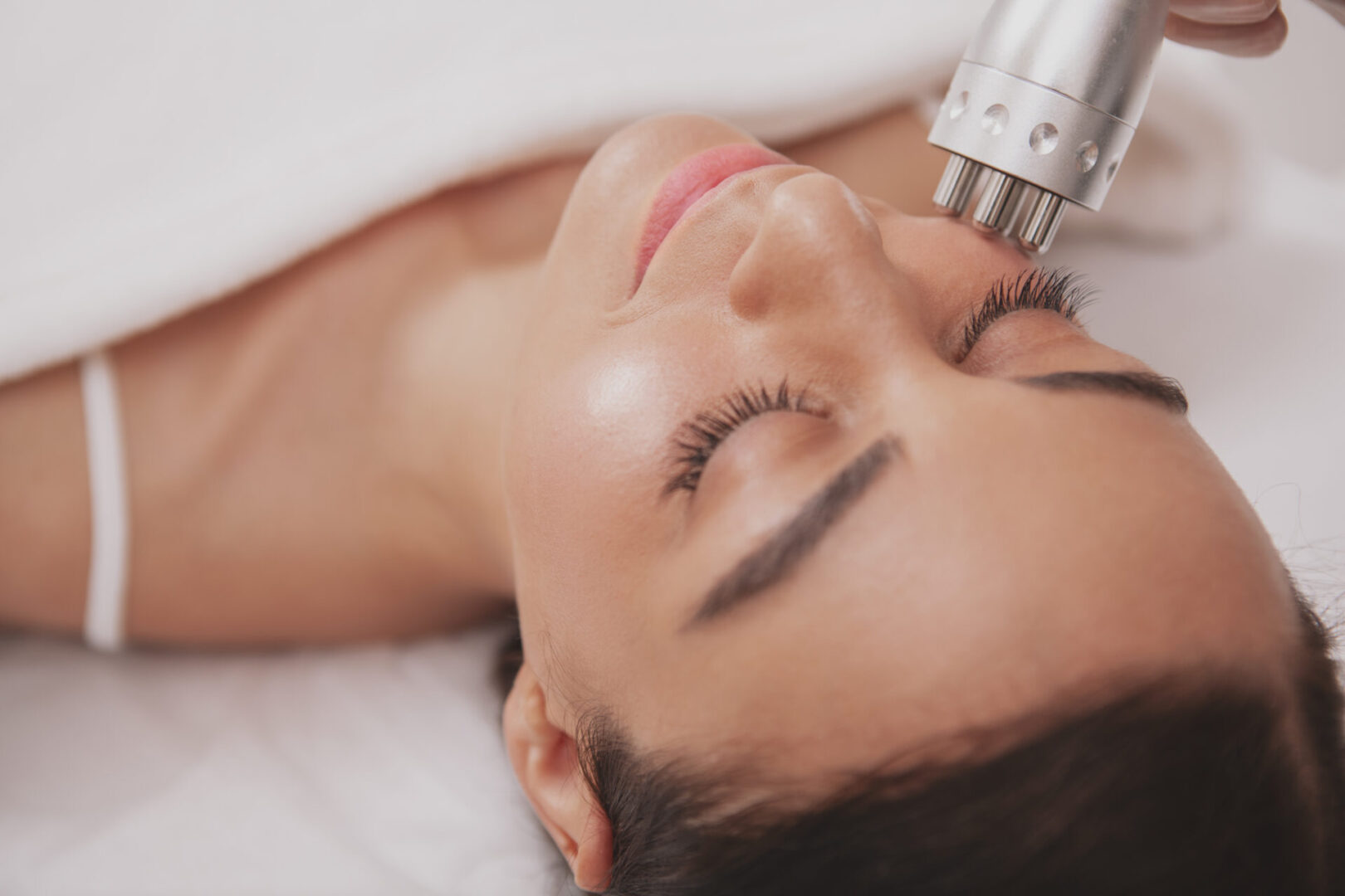 A woman laying down with her eyes closed.