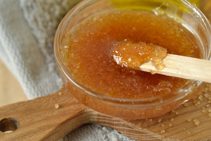 A wooden spoon in a bowl of food.